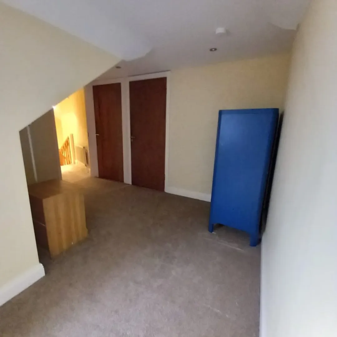 Attic Room Closet Blue Mattress Attic room with closet doors, blue folding mattress, and carpet flooring.