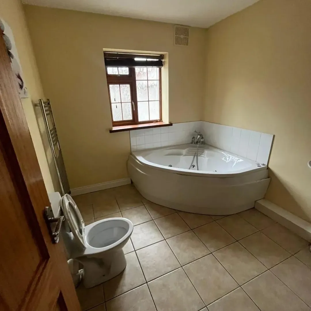 Bathroom Corner Jacuzzi Tub Toilet Bathroom with corner jacuzzi tub, toilet, heated towel rack, and small window.
