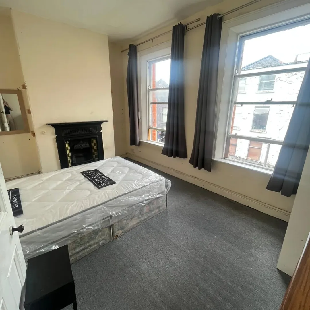 Bedroom Bed Fireplace Windows Grey Curtains Bedroom with bed, fireplace, and two windows with grey curtains.