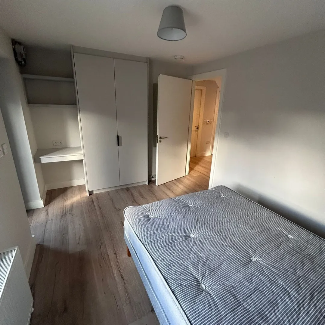 Bedroom Bed Wardrobe Desk Neutral Tones Cozy bedroom with bed, wardrobe, and desk. Neutral tones, wood floor.