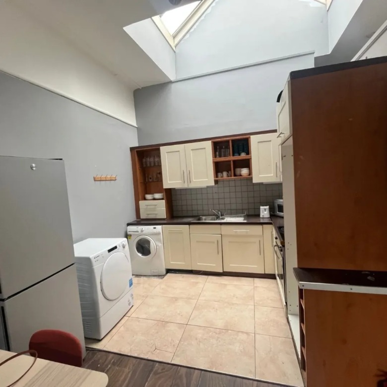 Bright kitchen with skylight, washing machine, and cream cabinets.