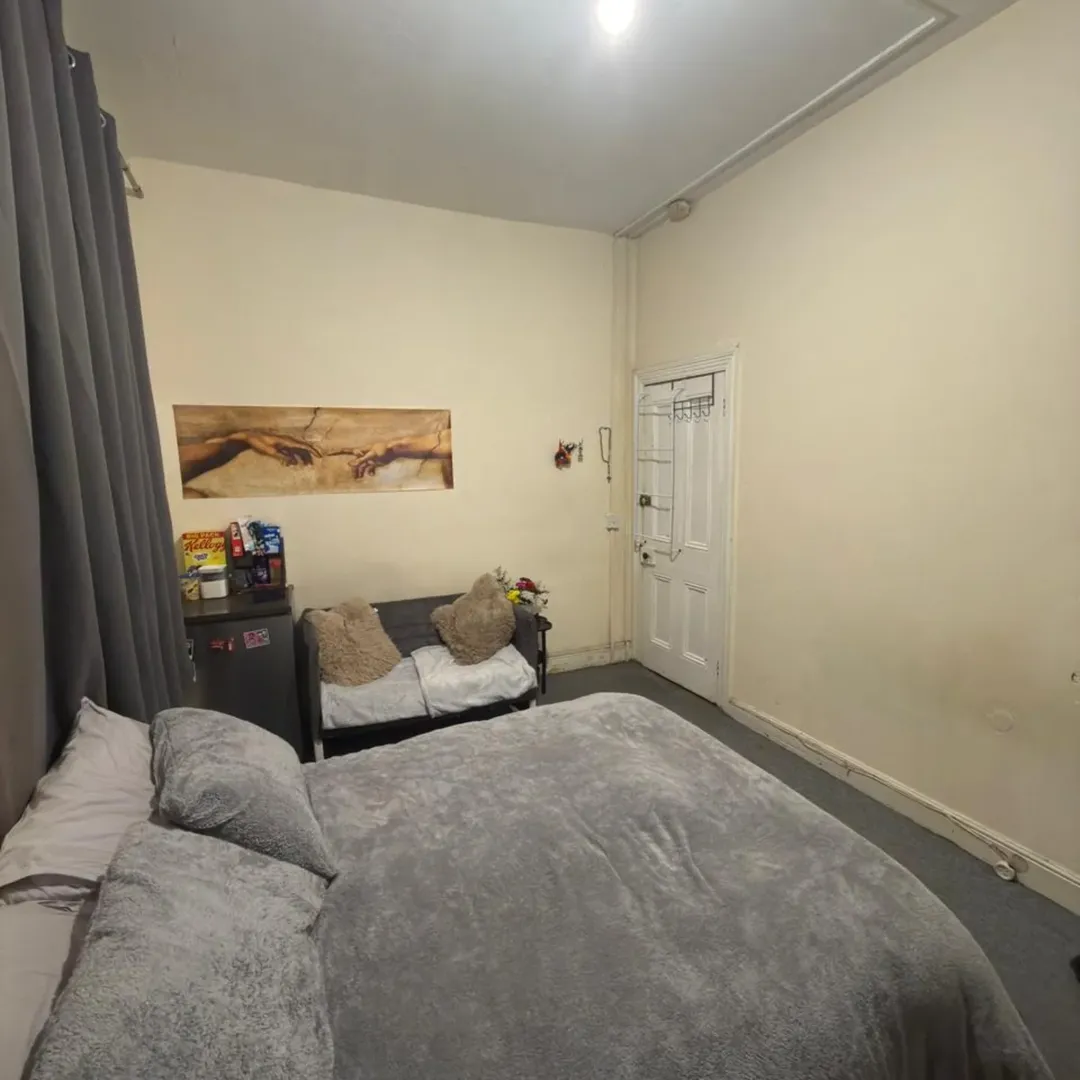 Cozy Room Bed Sofa Michelangelo Art Cozy room with bed, sofa, mini fridge, and art print of Michelangelo's Creation of Adam on the wall.