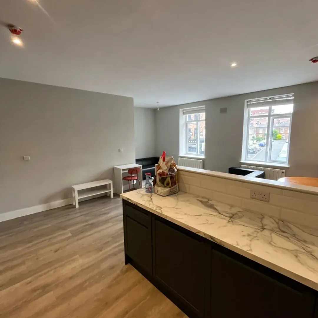 Bright modern apartment interior with kitchen counter and living area.