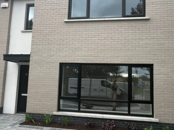 Modern two-story home with gray brick and black framed windows.