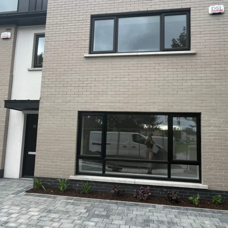 Modern two-story home with gray brick and black framed windows.
