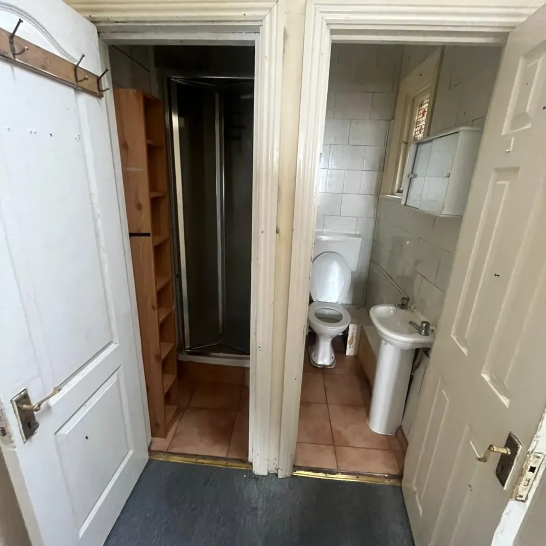 Small Bathroom Shower Toilet Sink 11 Small bathroom with shower, toilet, and sink, viewed through doorways.