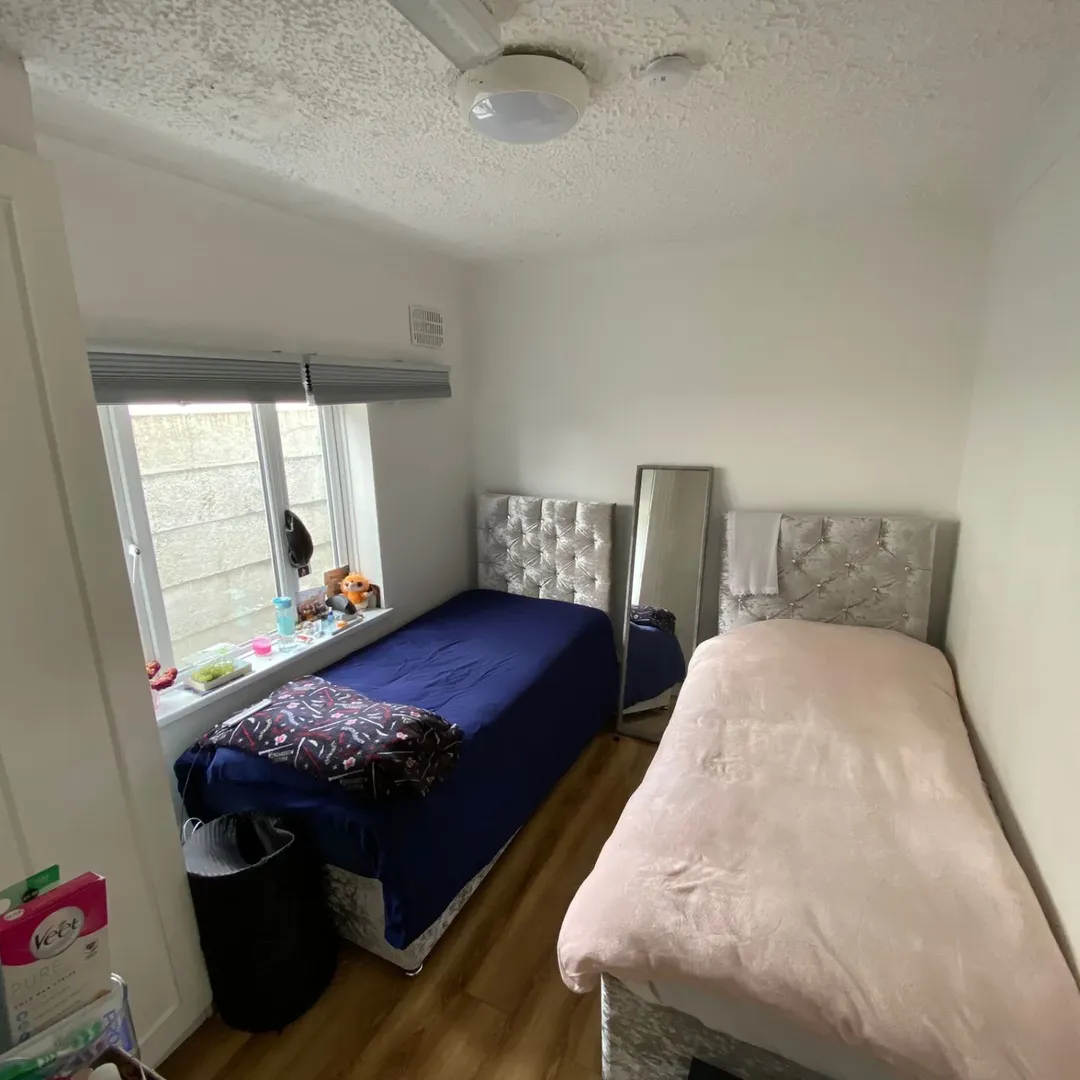 Small Bedroom Twin Beds Minimalist Decor Small bedroom with two twin beds, window, and minimalist decor.