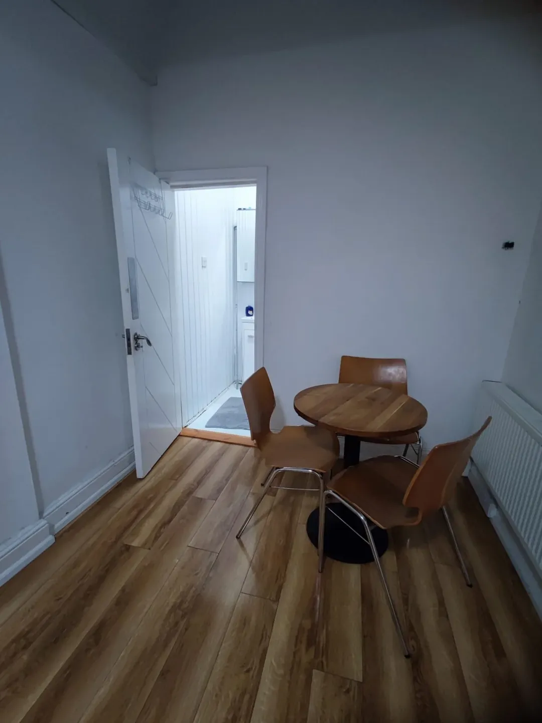 Small dining area with round table and three chairs in a modern apartment.