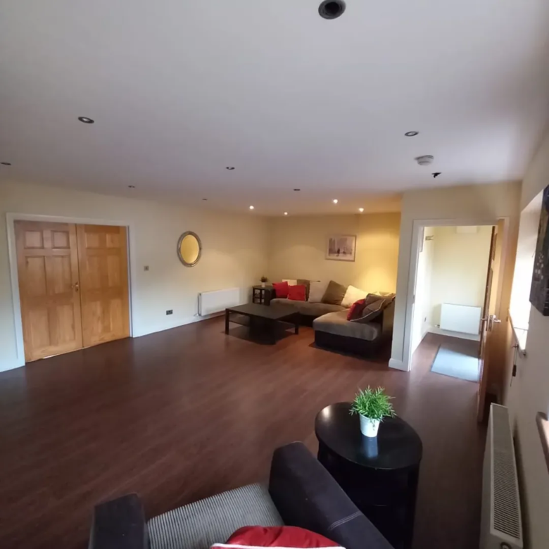 Spacious living room with brown furniture and wood flooring.