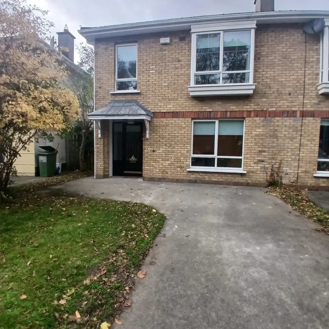 Two Story Brick House Driveway Lawn Two-story brick house with lawn and concrete driveway on cloudy day.