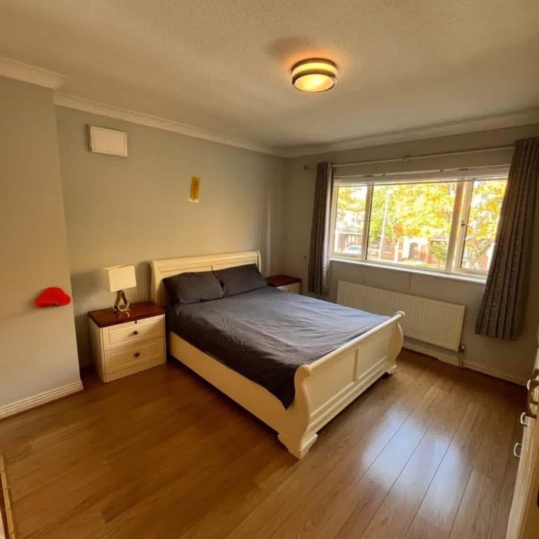 Bedroom with double bed, bedside tables, and window with natural light.