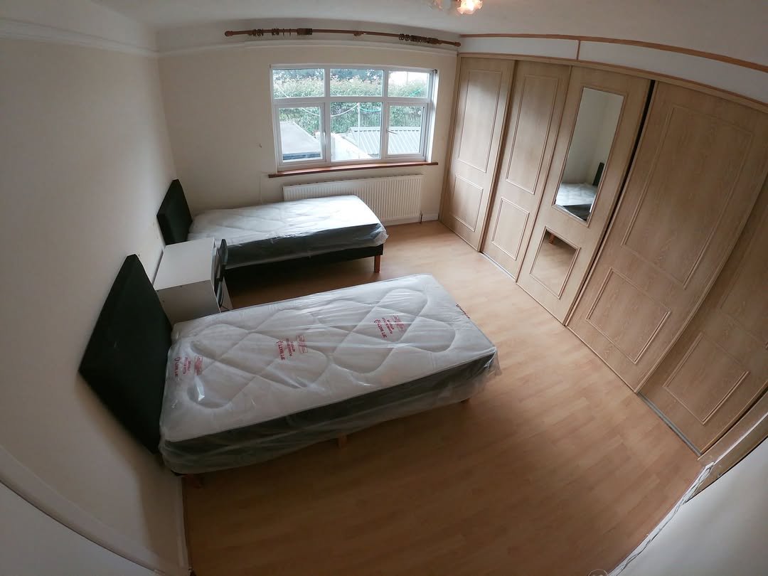 Bedroom Two Beds Wardrobe Window Bedroom with two beds, wardrobe, and window with natural light.