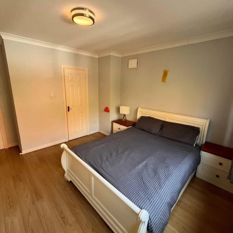 Bedroom with a white bed frame, gray walls, and wooden floors.