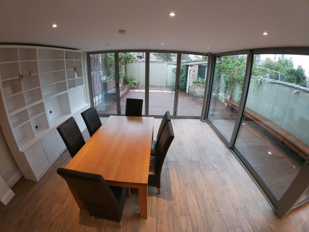 Dining Room Wood Table Patio Access Dining room with wood table, chairs, and built-in shelving, leading to a patio.
