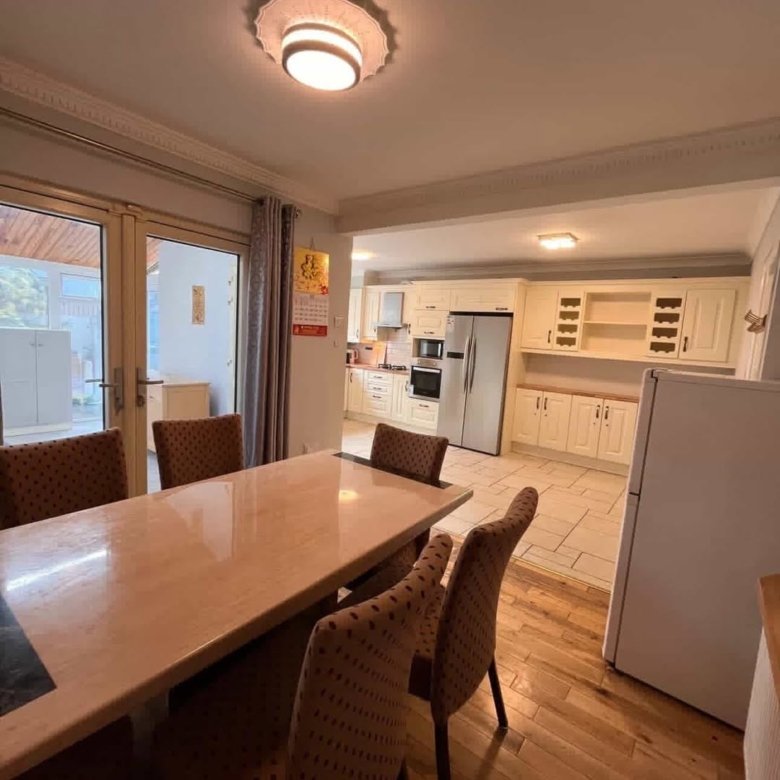 Bright kitchen with dining area, featuring a table, chairs, and modern appliances.