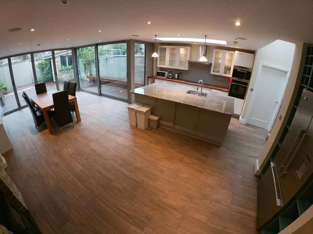 Modern Kitchen Island Dining Area Modern kitchen with island, dining table, and sliding glass doors to patio.
