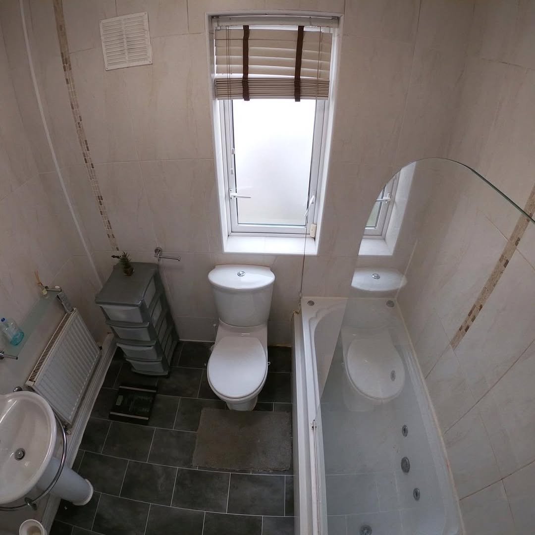 Small Bathroom Toilet Tub Sink Small bathroom with toilet, tub, sink, and tile walls.