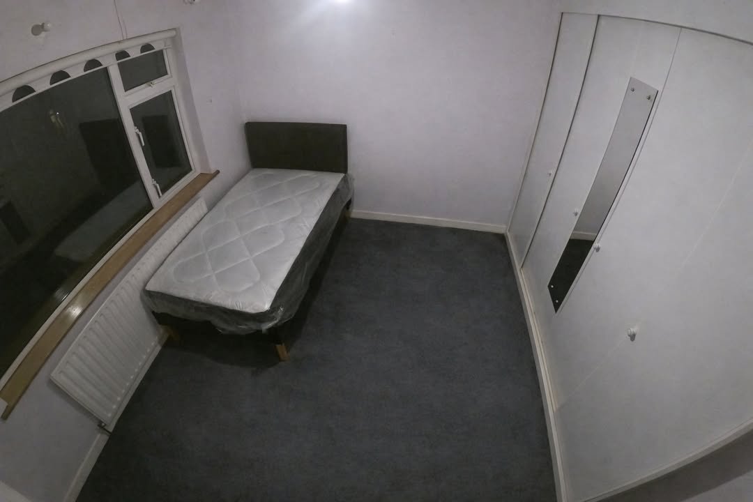 Small bedroom with single bed, wardrobe, and window.