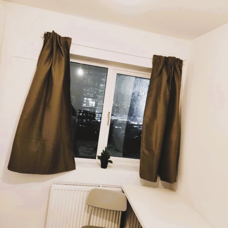 Cozy room with window view of city lights at night and a small desk. – Ghar.ie property listing