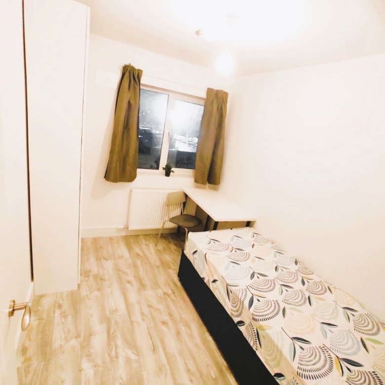 A tidy single bedroom with a bed, desk, and wardrobe, featuring light wood flooring and neutral decor. – Ghar.ie property listing