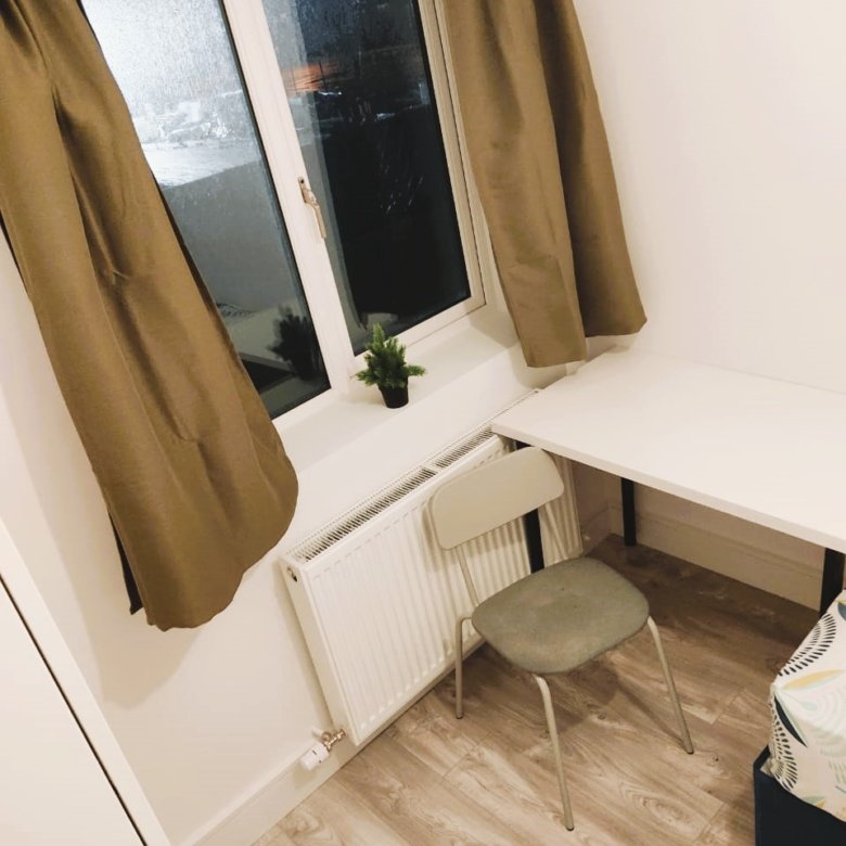 Small room with desk, chair, radiator, and window with brown curtains. – Ghar.ie property listing