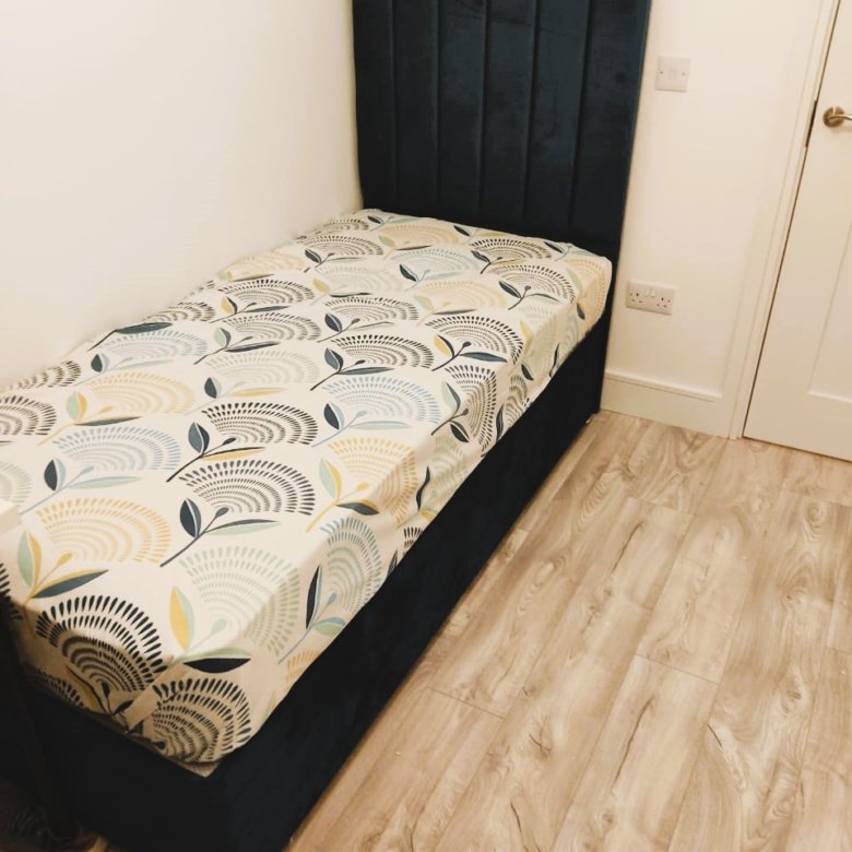 Single dark teal upholstered bed with a botanical print duvet in a bedroom. – Ghar.ie property listing